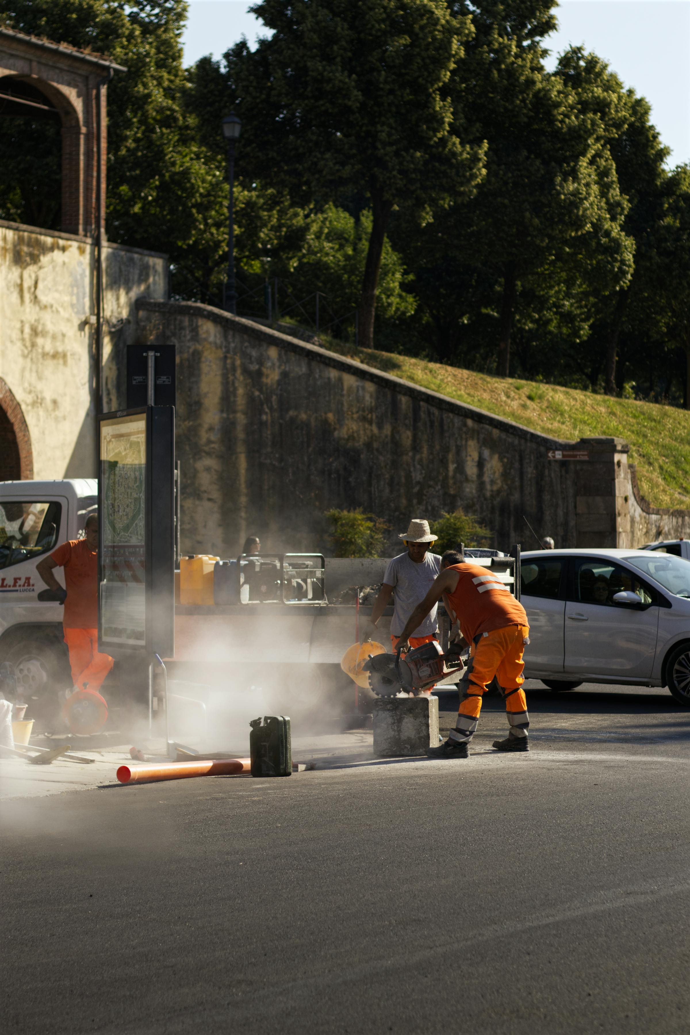 Sicherungskraft in oranger Warnkleidung an einer Arbeitsstelle bei Tageslicht