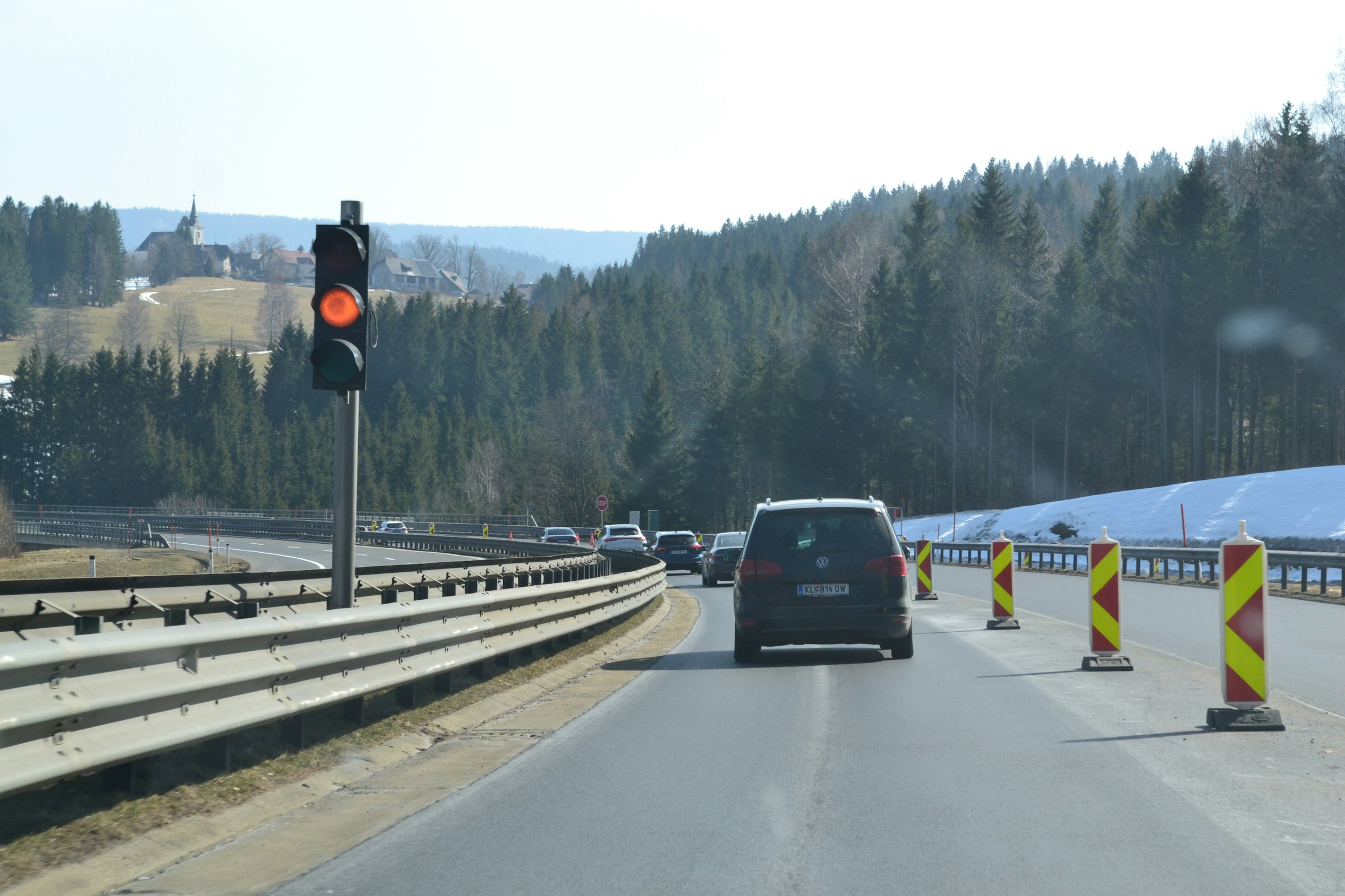 Mobile Baustellenampel und Leitbaken an einer Fahrbahnverengung